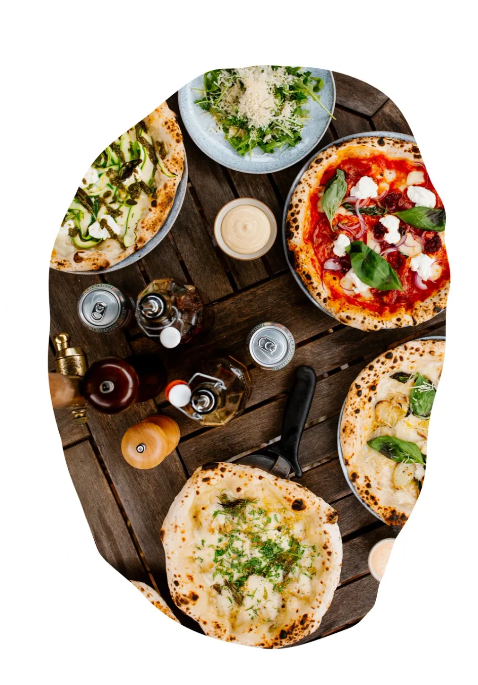 Pizzas and sides on a wooden table